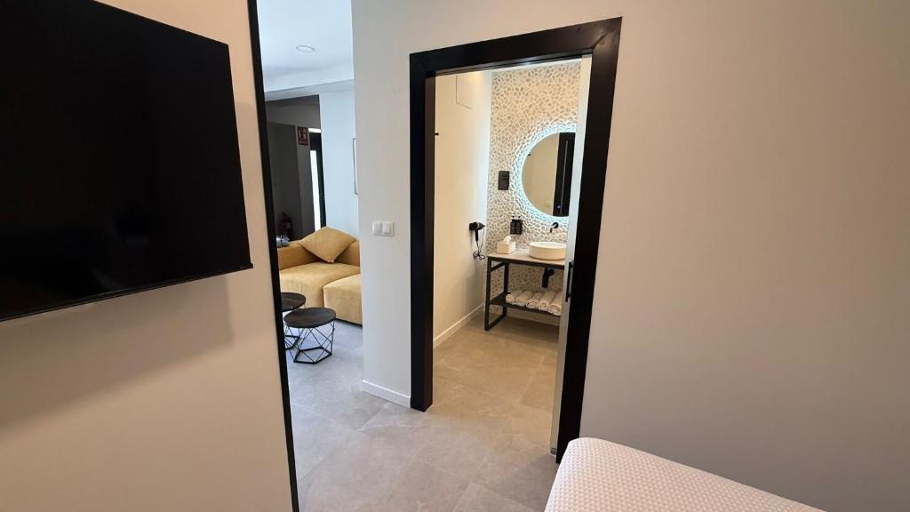 a view of a living room with a television and a mirror at Bormujos Suites Sevilla in Bormujos