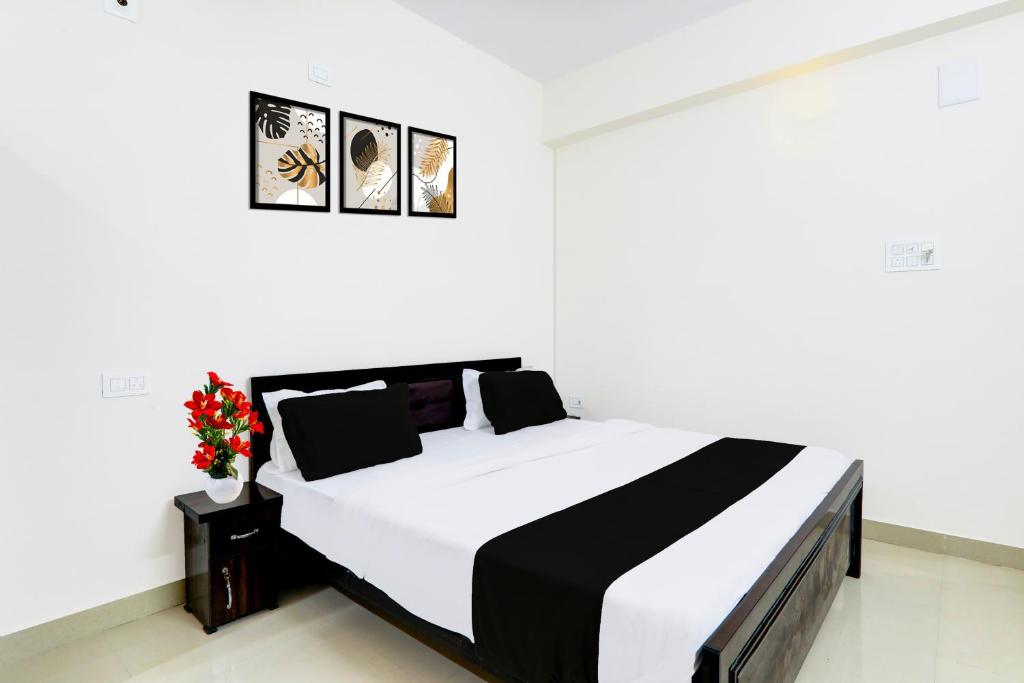 a bedroom with a black and white bed and flowers at Super Hotel O Kadam Ghat Near Ashok RajPath in Patna