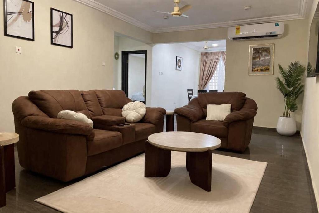 a living room with two couches and a table at ENA Apartments in Apenkwa
