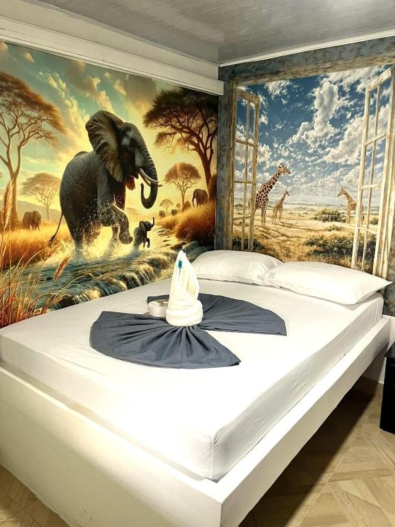 a bedroom with a mural of an elephant and giraffe at Sabana Africana in Puerto Triunfo