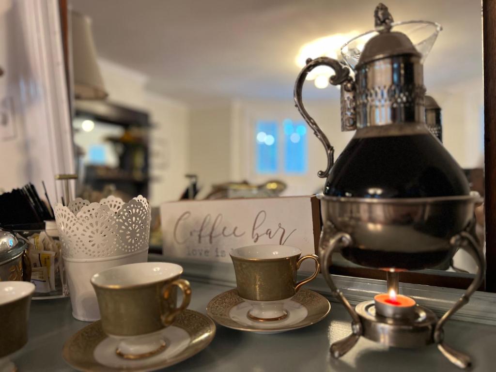 a kitchen counter with two cups and a tea kettle at Ann Street Inn & Garden in Beaufort