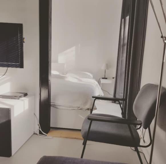 pokój z krzesłem, łóżkiem i telewizorem w obiekcie Tiny house Weerdinge w mieście Emmen