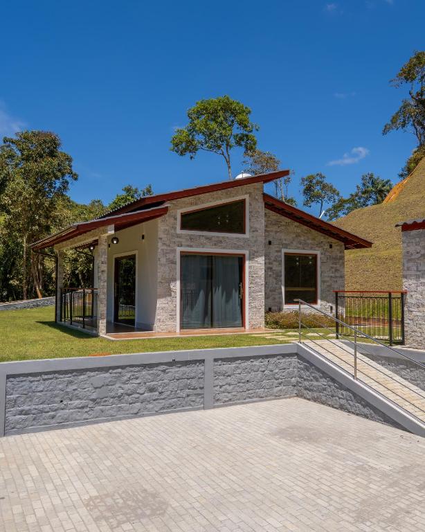 a house with a stone walkway in front at Chalé Estalagem Sítio Sossego in Domingos Martins