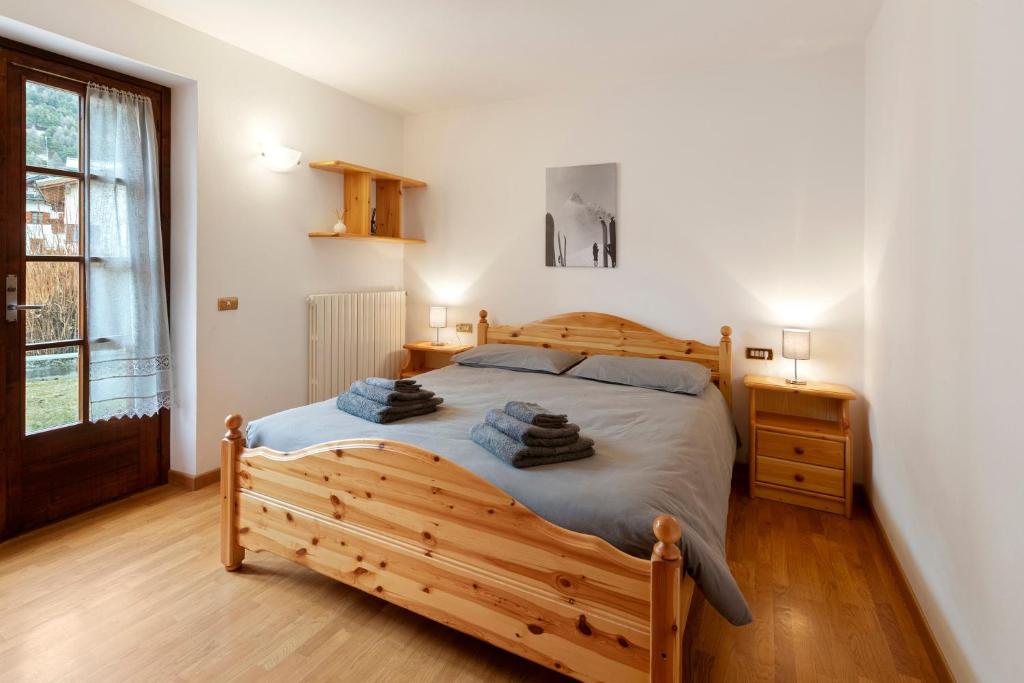 a bedroom with a wooden bed and a window at Fior di montagna in Bormio