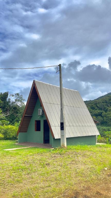 ein kleines Haus mit einem Pfahl auf einem Feld in der Unterkunft Chalé Belém in Eldorado