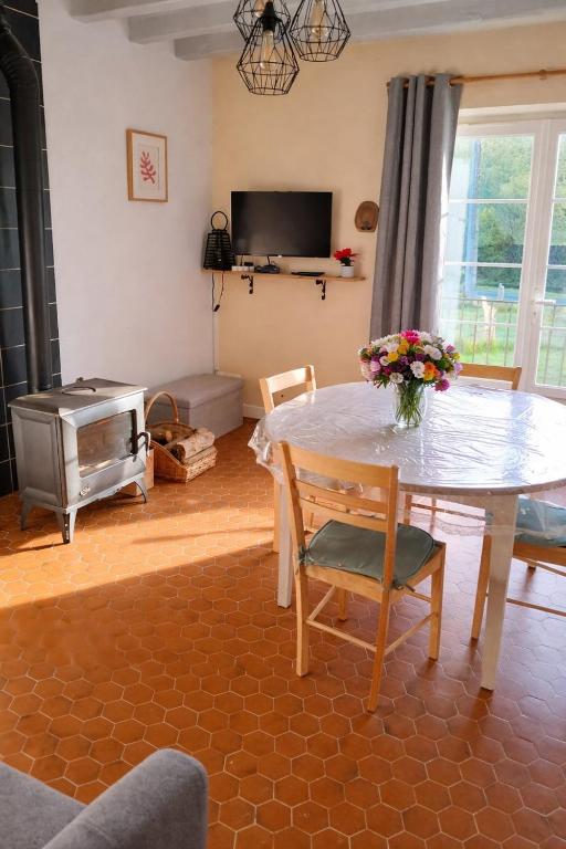 een woonkamer met een tafel en een tv bij La source in Le Grand-Pressigny