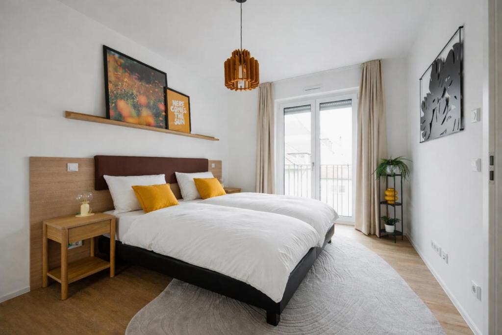 a bedroom with a large bed with yellow pillows at LIVELY am Kaiserberg Duisburg in Duisburg