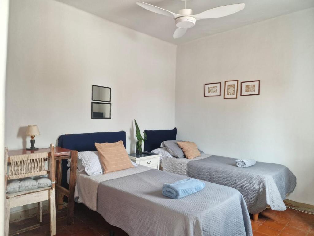 a room with two beds and a ceiling fan at Alojamiento La Liboria, solo mujeres in Córdoba