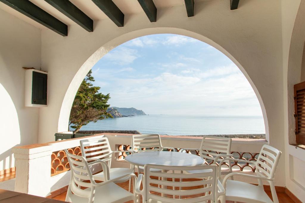 an arched window in a dining room with a table and chairs at Terraza al Mar La Fosca in Palamós
