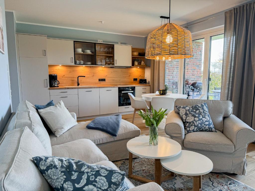 a living room with two couches and a kitchen at Ferienwohnung Gartenidyll am Dümmer See in Lembruch