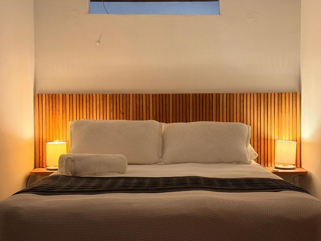 a bedroom with a large bed with two lamps at Casinha Verde, Itacaré in Itacaré