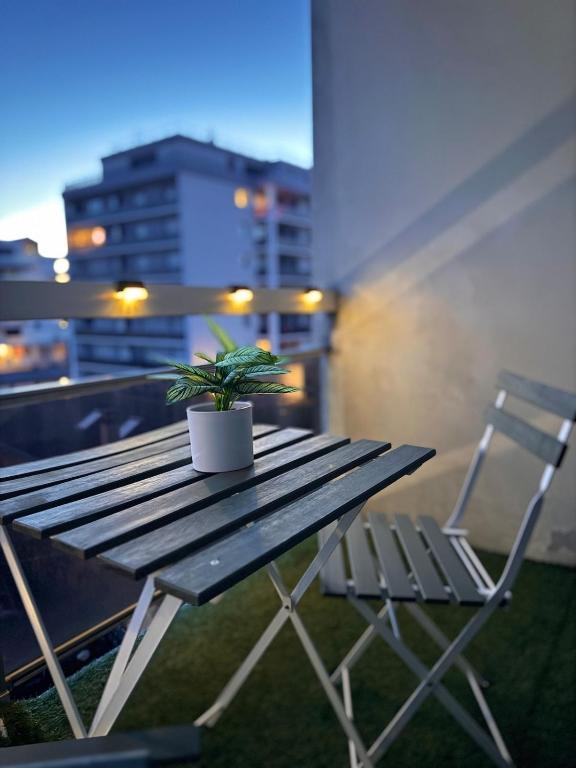 a potted plant sitting on a wooden table on a balcony at Pearly EuroPoint in Saint-Louis