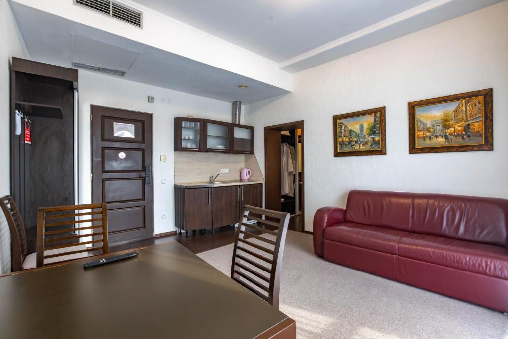 a living room with a red couch and a table at HARMONY Apart in Truskavets