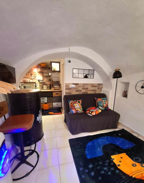 a living room with a couch and a table at Tiny studio, rustic style, historic center in Sanremo