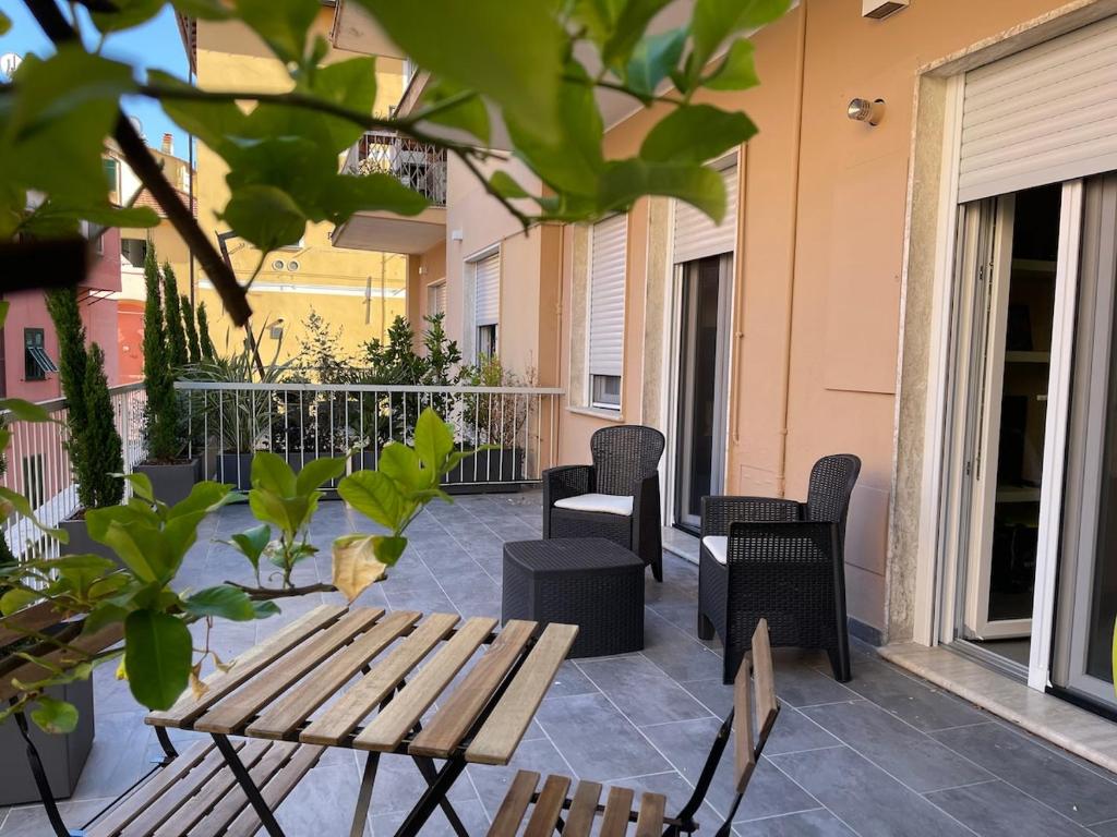 a patio with a wooden table and chairs at Casa di WR in Imperia