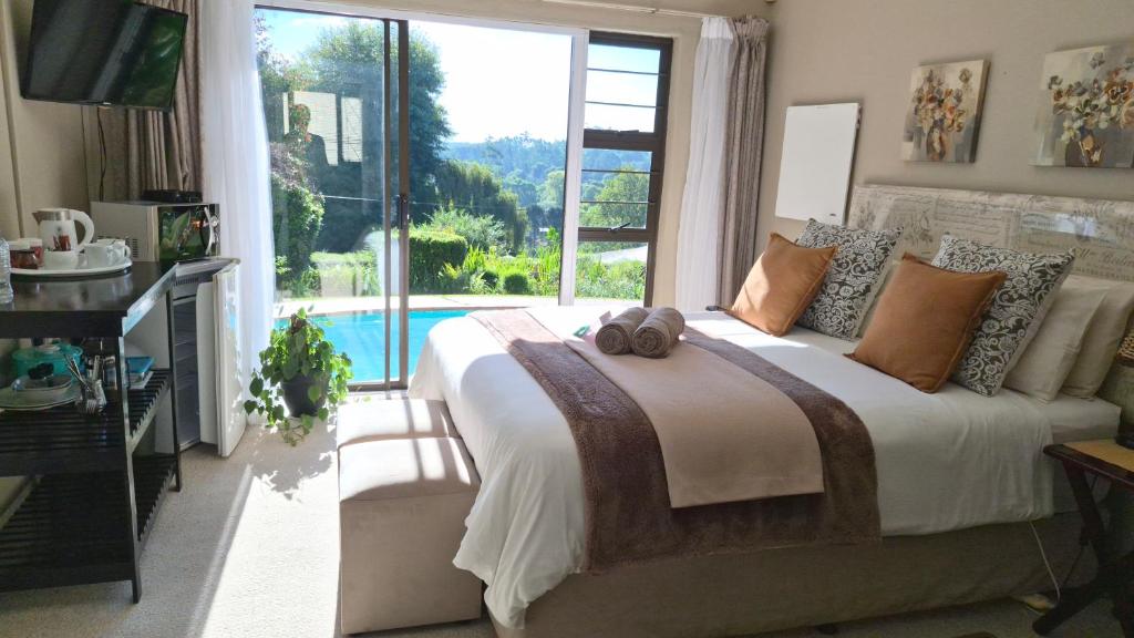 a bedroom with a large bed and a large window at King's Hill Guest House in Hilton