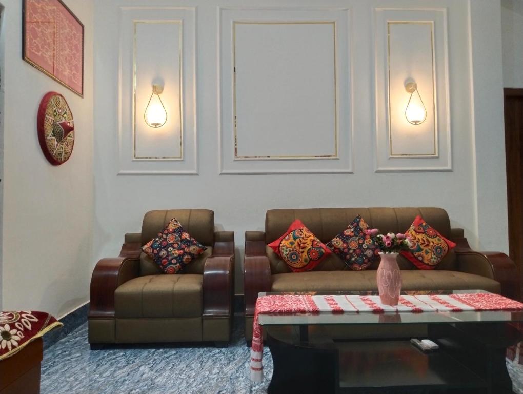 a living room with two couches and a table at Bhanu Homestay in Nowgong