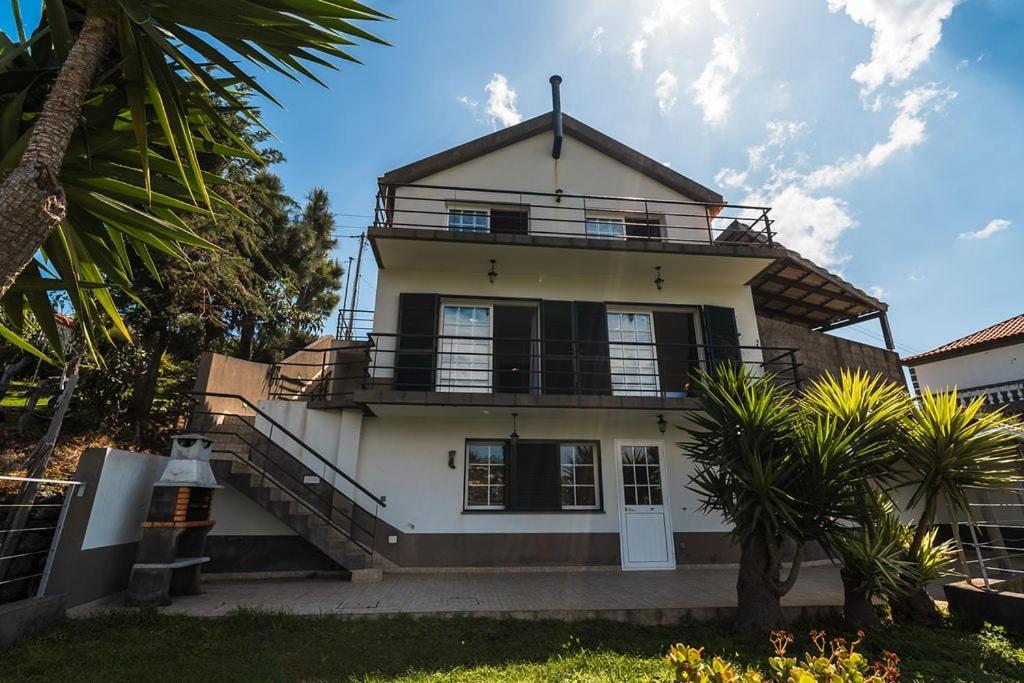 a large white house with a balcony at GuestReady - Casa das Estrelas in Estreito da Calheta