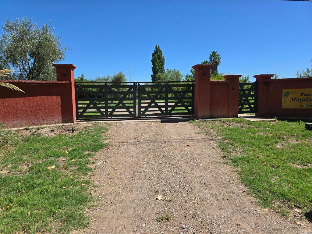a gate in a field with a dirt road at Finca Magdalena Casa de Campo in San Rafael