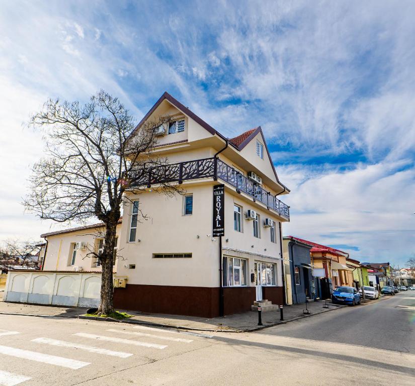 a white building on the corner of a street at Villa Royal in Craiova