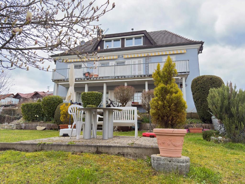 a house with a table and chairs in front of it at Ferienappartement Pauli in Hagnau