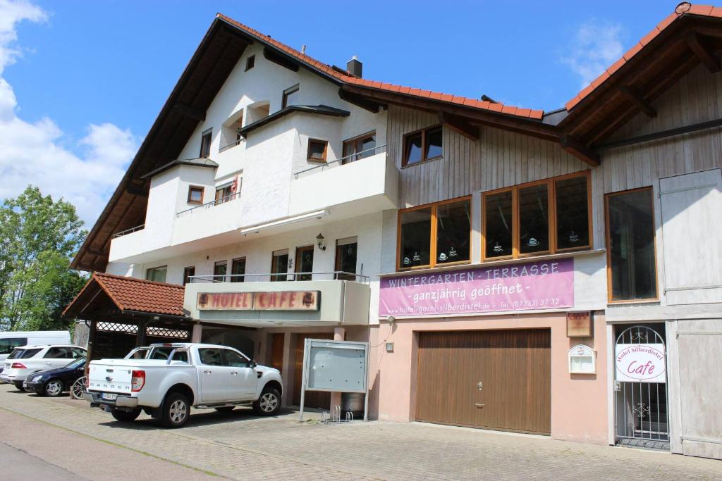 a white truck parked in front of a building at Hotel Garni Silberdistel in Nenningen