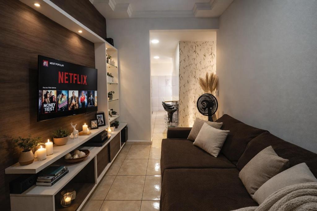 a living room with a couch and a tv at Apartamento Trindade - Centro de Manaus a 5 minutos do Teatro Amazonas in Manaus