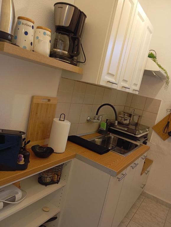 a kitchen with white cabinets and a sink at Konstantinos in Chorto