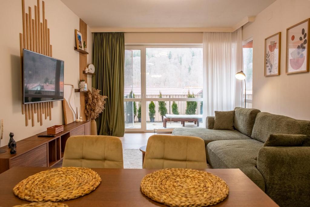 a living room with a couch and a table at Forestline Apartment Sinaia in Sinaia