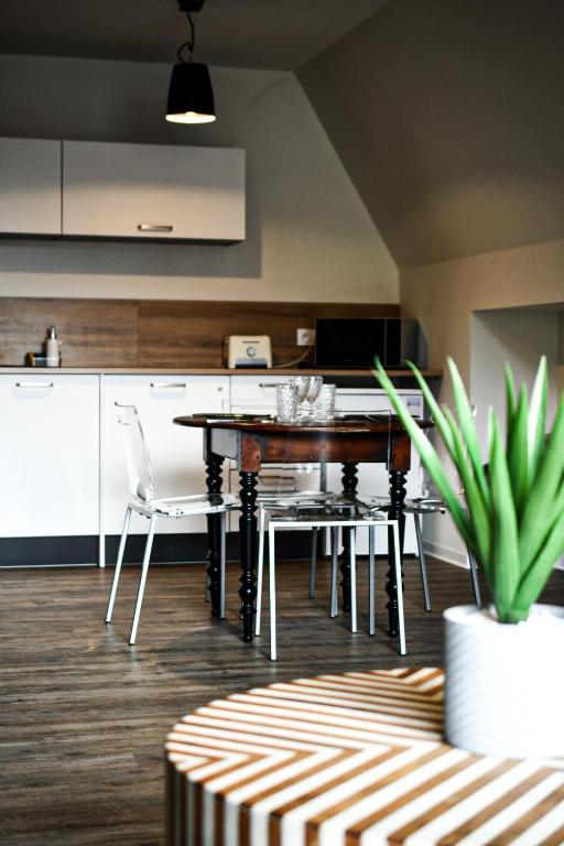 a kitchen with a table and chairs in a room at Les Appartements du Vignoble in Kientzheim
