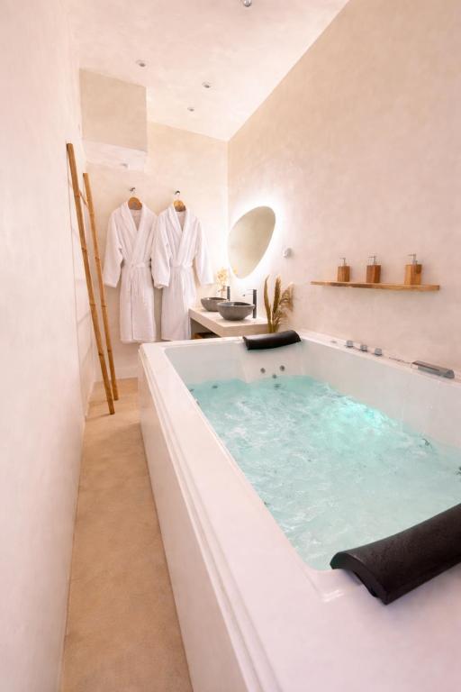 a bathroom with a bath tub and a sink at MEEY Suite with Private Spa in Saint-Étienne