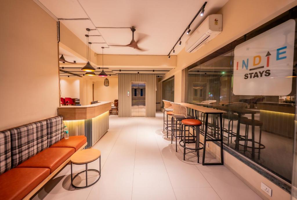 a restaurant with a bar with stools and tables at Indie Stays Studio Kharadi in Pune