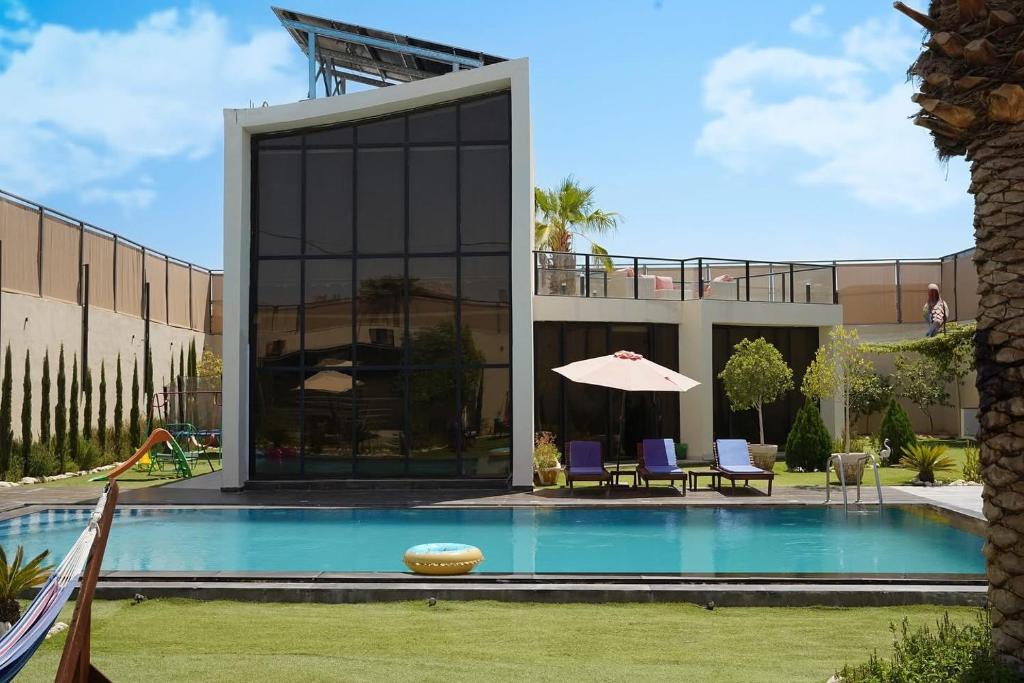 a house with a swimming pool in a yard at Atlantis The Palm Villa 2 in Al Rama