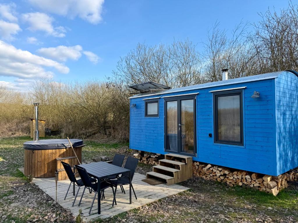 a blue tiny house with a table and chairs at Maringotka pod Hrází in Drahonice