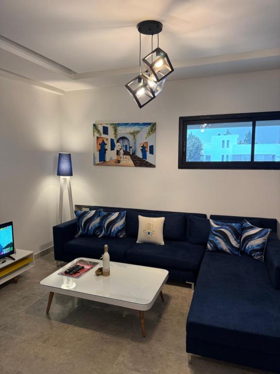 a living room with a blue couch and a coffee table at L'œil de Fatma in Tunis