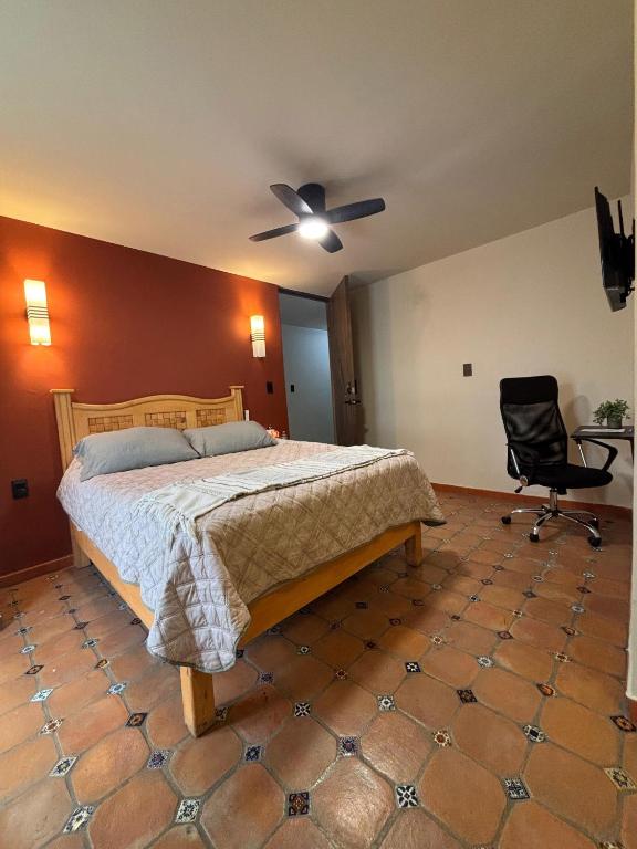 a bedroom with a bed and a chair at La Estancia de Rey David in San Luis Potosí
