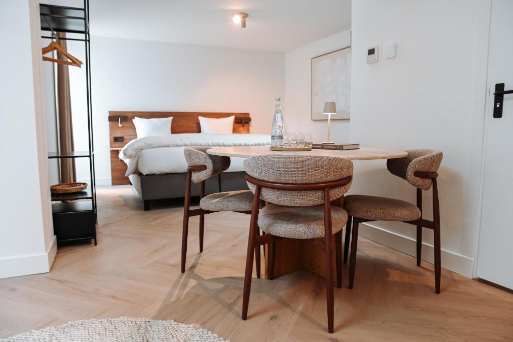 a bedroom with a bed and a table and chairs at Residence Paradis in Zandvoort