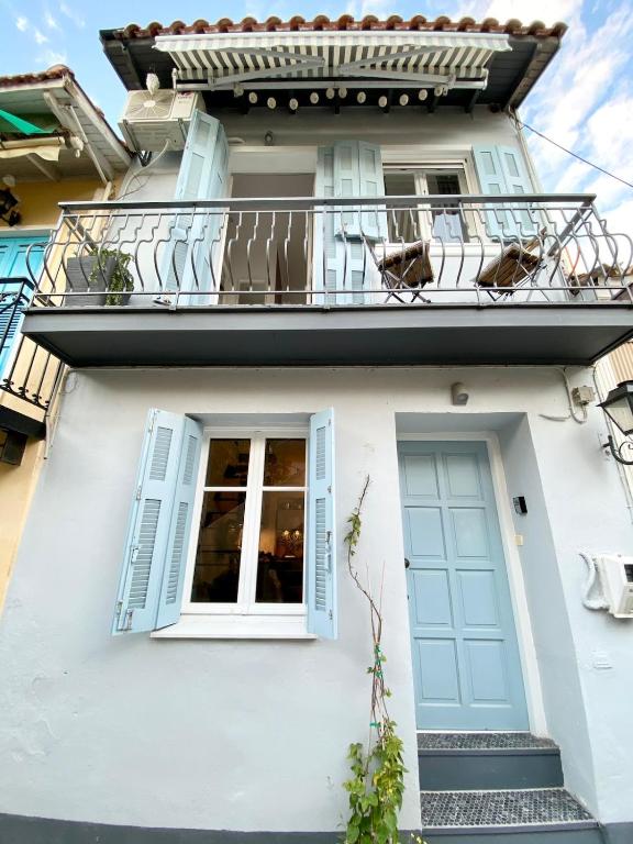 a white house with a balcony and a door at Apollo House in Lefkada
