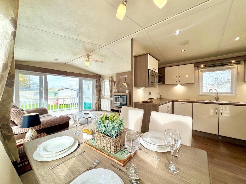 a kitchen and dining room with a table and chairs at Oaklands Holiday Park in Saint Osyth