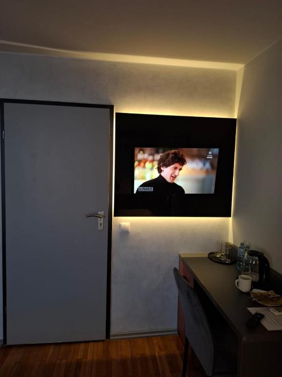 a television on the wall of a room with a table at Ambrozja in Strzelin