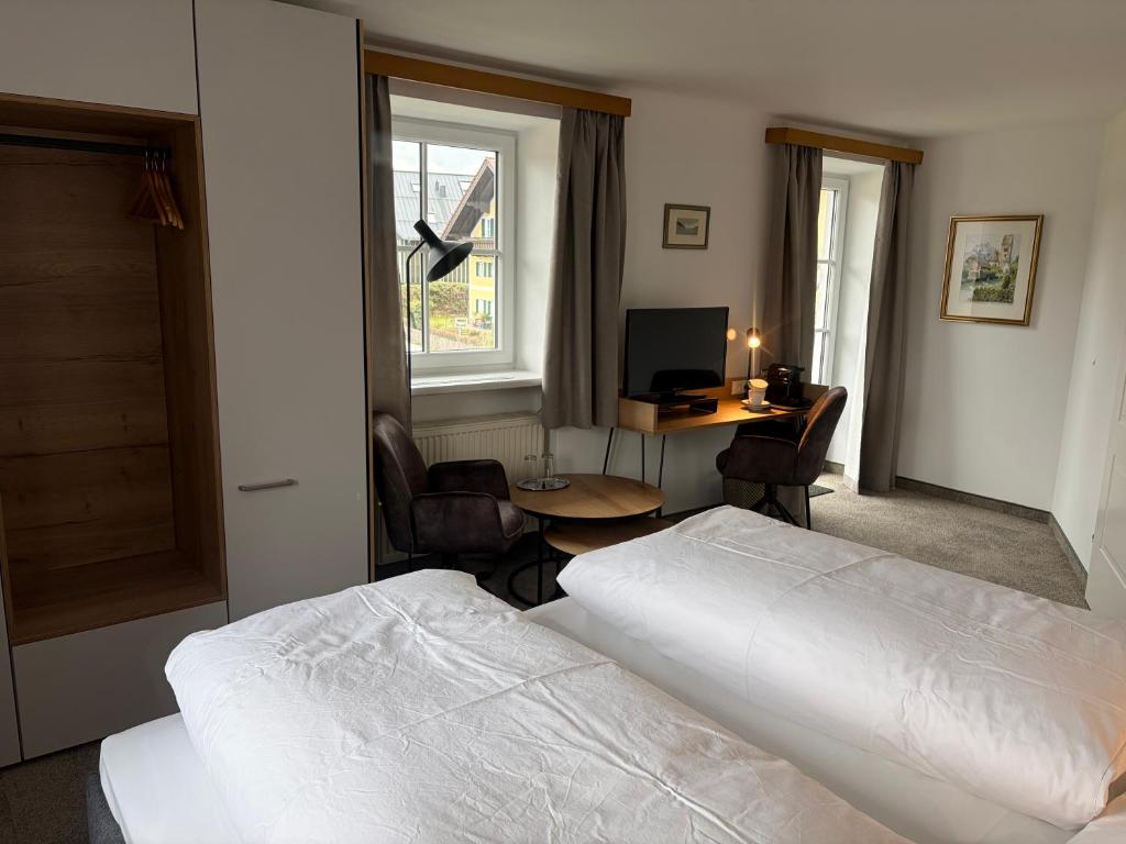 a bedroom with a bed and a desk with a computer at Pension Schiessling in Anif