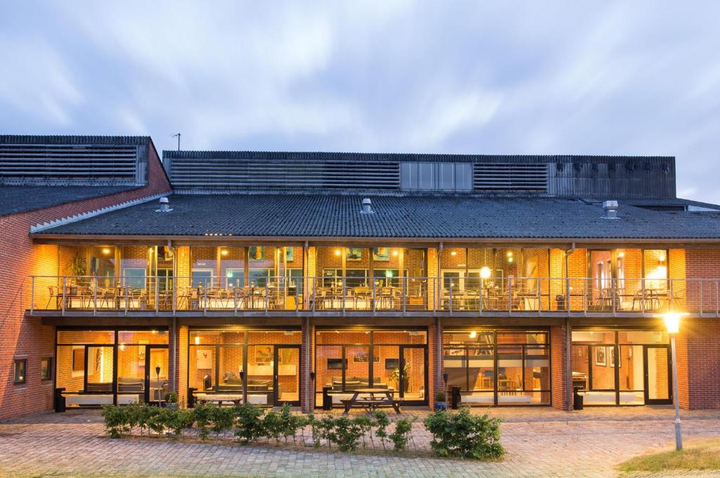 ein großes Backsteingebäude mit Terrasse und Patio in der Unterkunft Hotel Fuglsocentret, BW Signature Collection in Knebel