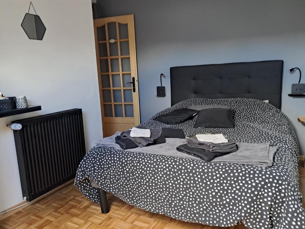 a bedroom with a bed with black and white polka dots at Chambres d'hôtes chez Peggy et Eric chambre indus in Équevillon