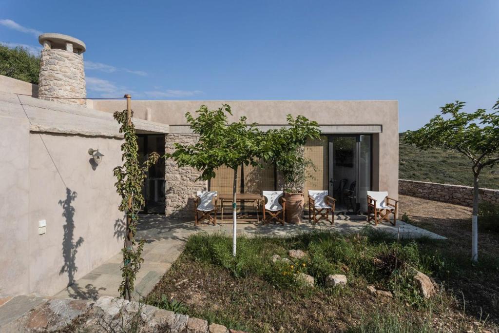 a home with a patio with a table and chairs at Oxalis Villas in Perlengiánika