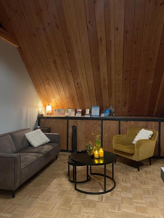 a living room with a couch and a table at B&B Aan t End in Kootwijkerbroek