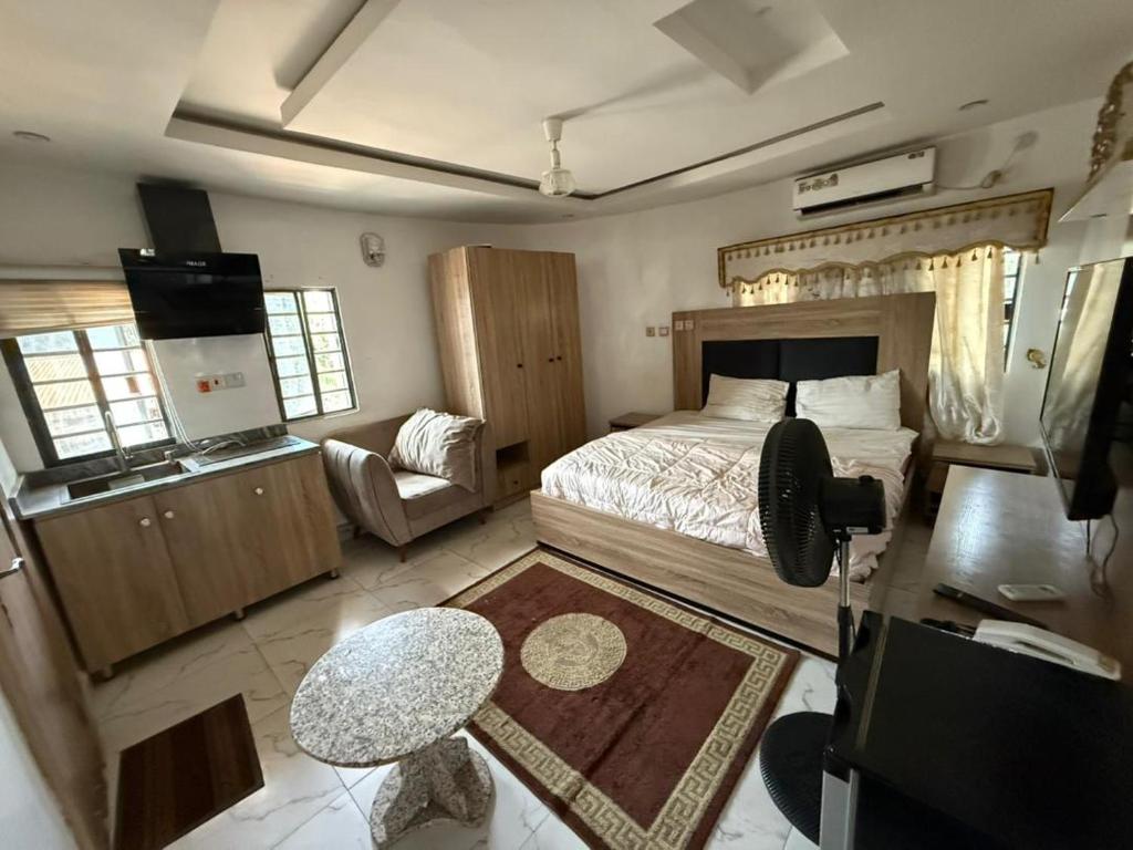 a bedroom with a bed and a table and a couch at Majesty Apartment in Asaba
