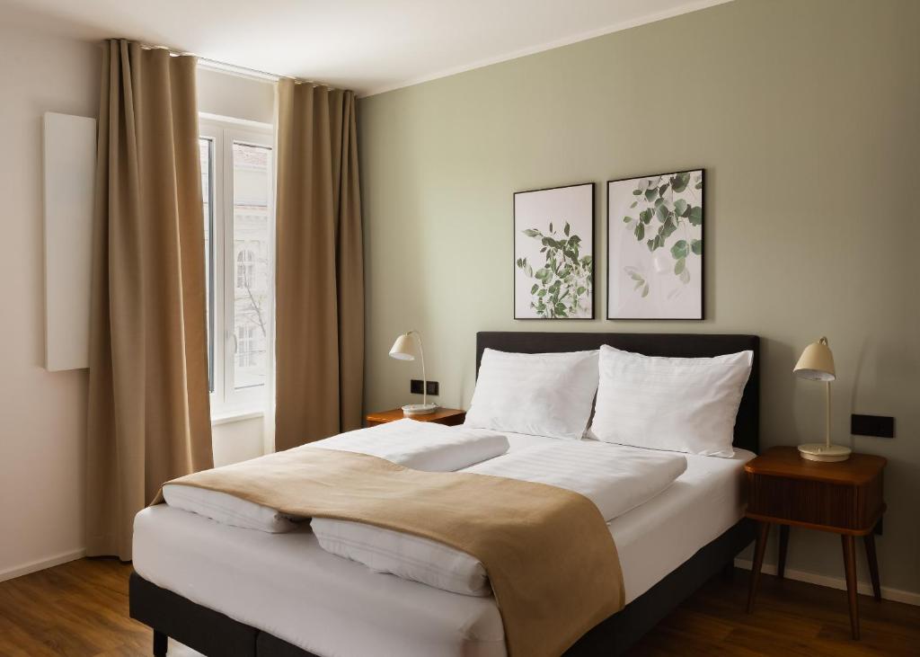 a bedroom with a large bed and a window at Limehome Wels Ringstraße in Wels