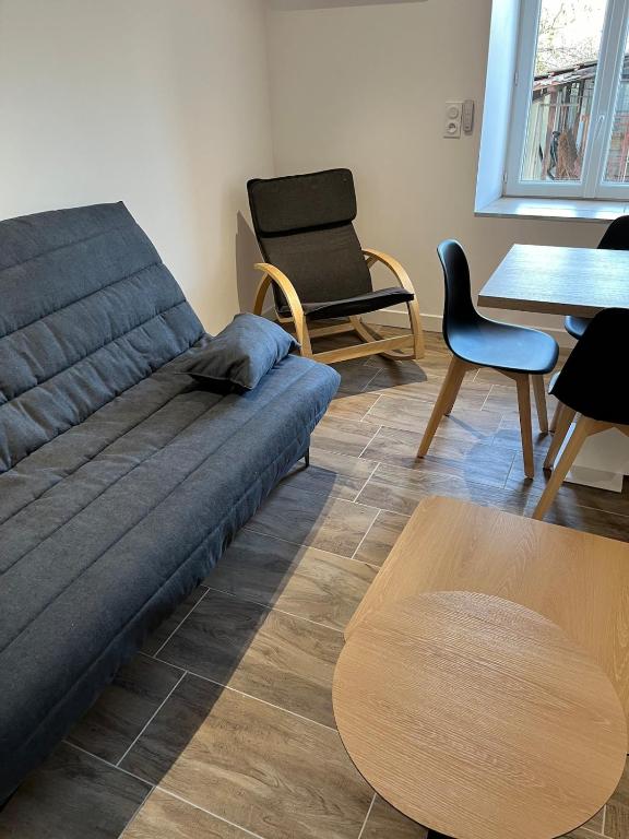 a living room with a couch and chairs and a table at Maison f3 climatisée in Montceau-les-Mines