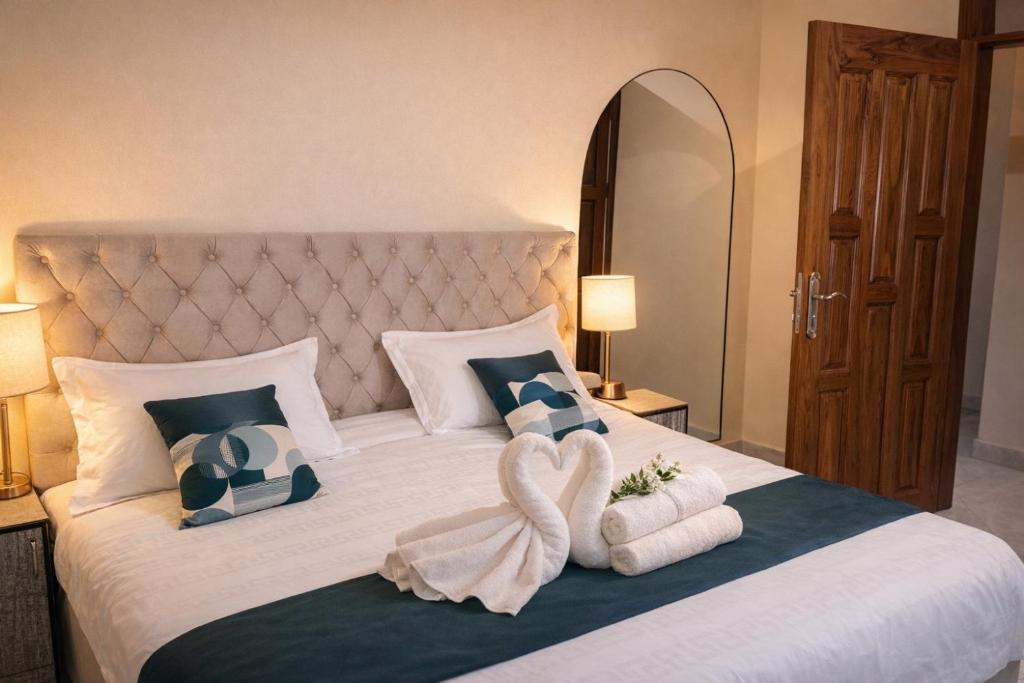 a bedroom with a large bed with towels on it at Cozy Apartment in Munyonyo in Munyonyo