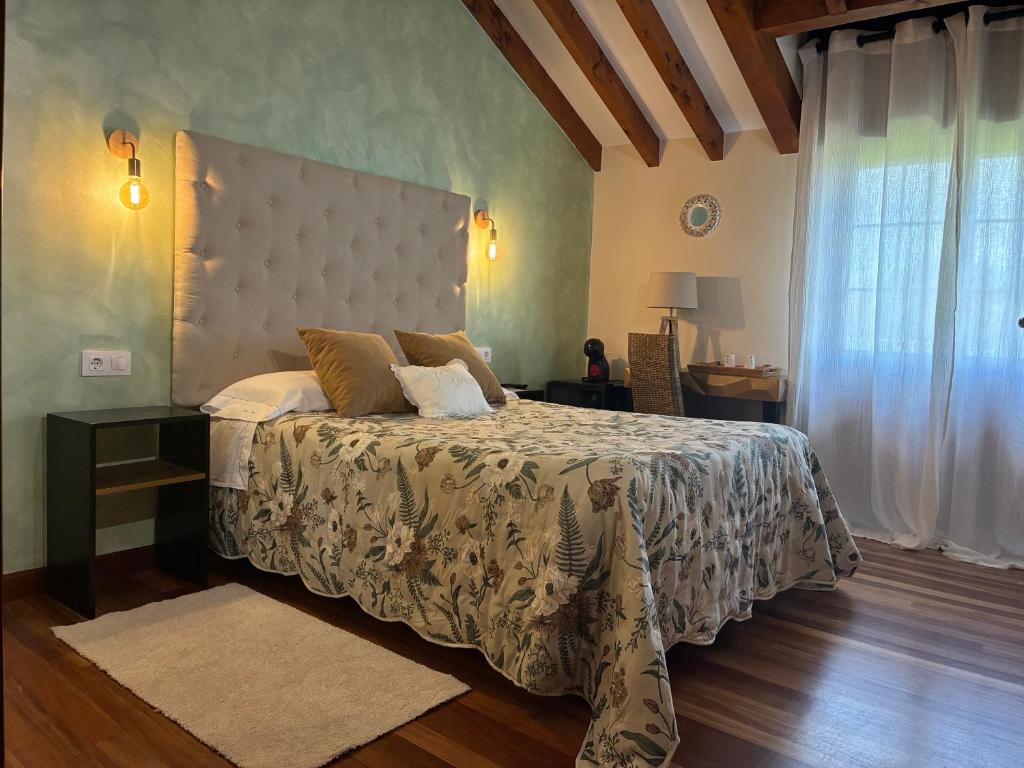 a bedroom with a large bed and a window at Posada El Jardin in Santillana del Mar
